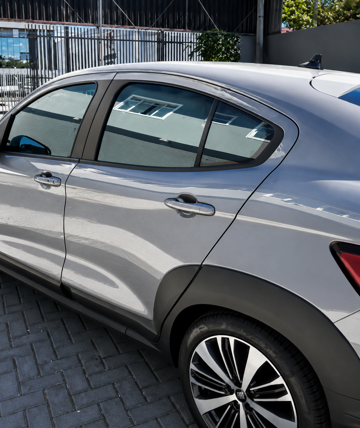 Detalhe lateral de Fiat cinza mostrando o acabamento da película nos vidros.